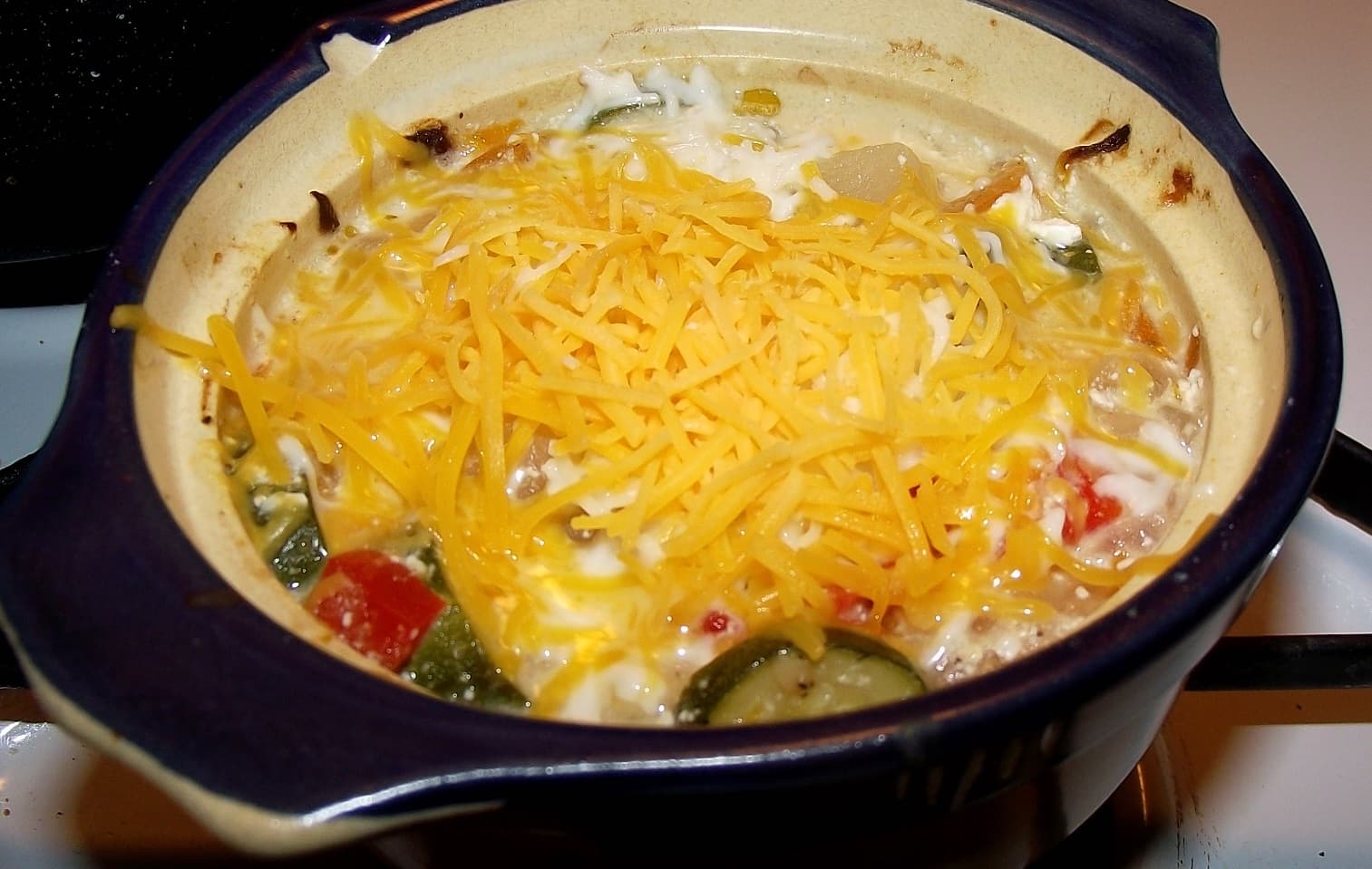 Potato, zucchini, red bell pepper, with bacon and herbs baked in a pot.