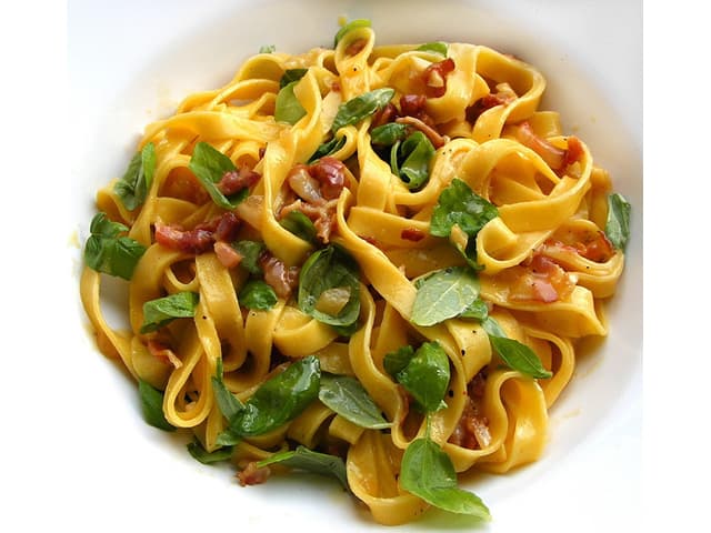 tagliatelle alla carbonara garnished with fresh basil