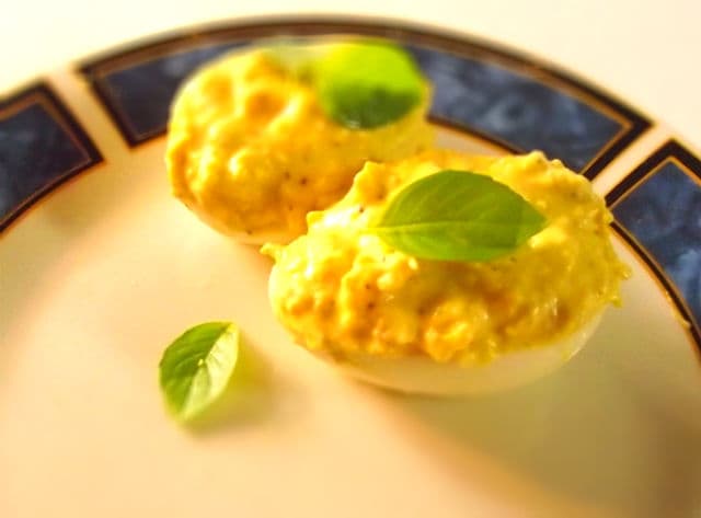 Deviled eggs with shrimp, yellow mustard and basil.